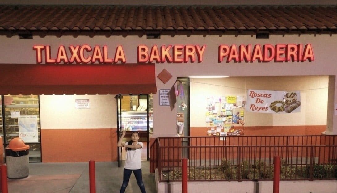 Tlaxcala Bakery Panaderia storefront at night with red neon signage